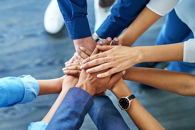 ESGInvestmentPrinciples_GettyImages-1140128516_660x440 Hands together for team cheer